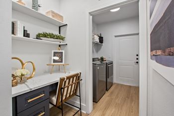 A kitchen with a white counter top and a wooden chair.